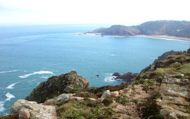 Côte sauvage de Jersey avec falaises, baie turquoise et lande au premier plan
