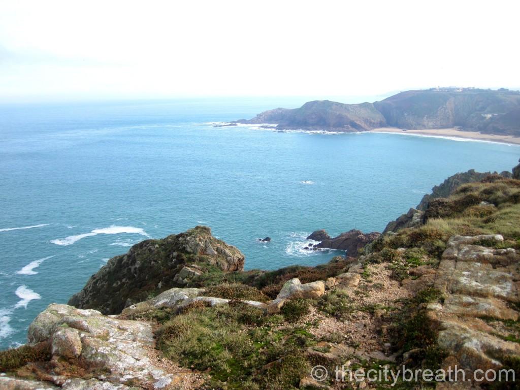 Côte sauvage de Jersey avec falaises, baie turquoise et lande au premier plan