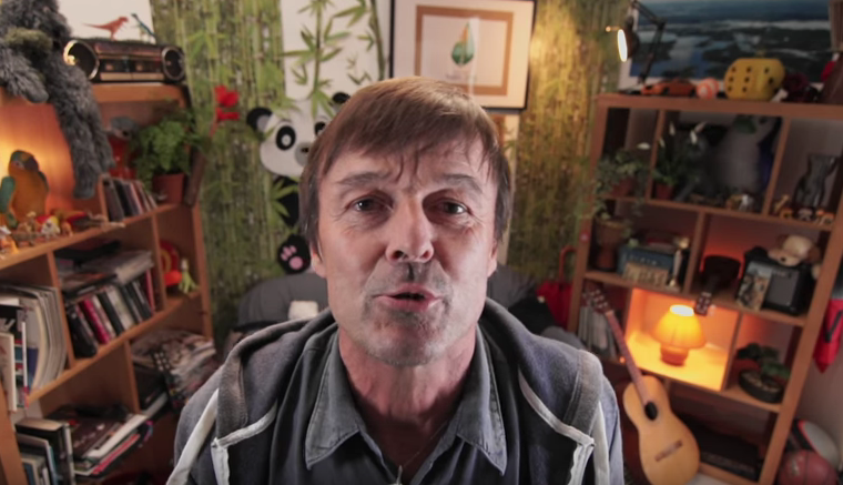Nicolas Hulot face caméra dans une pièce aux étagères décorées